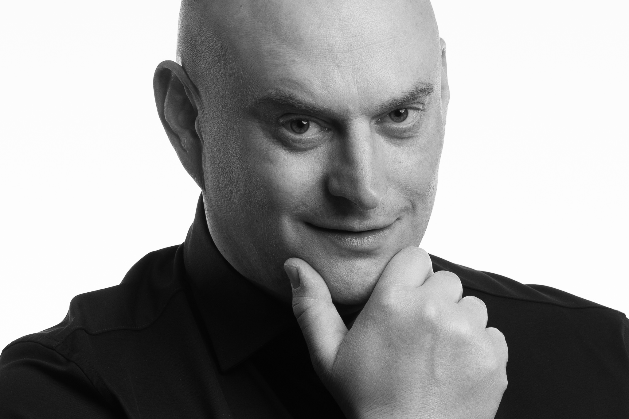 Černobílý portrét muže s rukou pod bradou